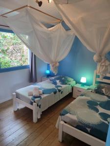 une chambre avec deux lits et une fenêtre dans l'établissement Villa zen Bali piscine privée 3 chambres lotissement les hauts de la vallée d'or, à Saint-François