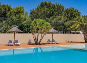 een zwembad met stoelen en parasols en een palmboom bij Mobilhome 3 étoiles - Piscine - eehdbc in Sigean