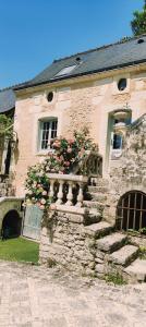 a stone building with a balcony with flowers on it at maison d'hôtes prince face au château du clos Luce in Amboise