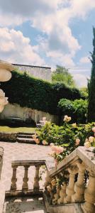 a garden with pink flowers and a stone bridge at maison d'hôtes prince face au château du clos Luce in Amboise