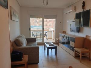 een woonkamer met een bank en een tafel bij Holidaytorremar-84-MED021 in El Borseral