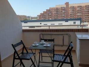 een tafel en stoelen op een balkon met uitzicht op een stad bij Holidaytorremar-84-MED021 in El Borseral