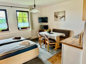Zimmer mit einem Bett und einem Tisch sowie einer Küche in der Unterkunft Ferienwohnungen 1 bis 4 "Pumphut's Scheune" in Lengenfeld