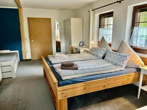 ein Schlafzimmer mit einem großen Holzbett in einem Zimmer in der Unterkunft Ferienwohnungen 1 bis 4 "Pumphut's Scheune" in Lengenfeld