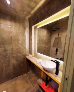 Hotel Windsor Mendoza في ميندوزا: حمام مع حوض ومرآة
