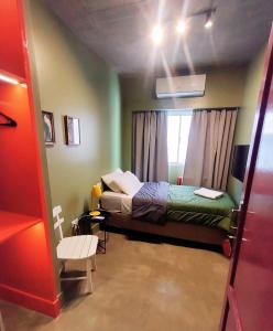 niewielka sypialnia z łóżkiem i oknem w obiekcie Hotel Windsor Mendoza w mieście Mendoza
