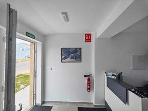 a hallway with a white wall with a fire hydrant at Pension Casa Pedro in Fisterra