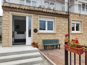 a green bench sitting outside of a building at Pension Casa Pedro in Fisterra