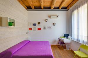 a bedroom with a purple bed and a desk at B&B Borgo Castello in Marostica