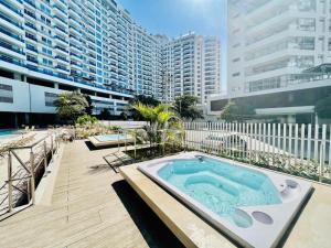 a hot tub on a deck next to a large building at apartamento luxury, Frente al mar in Gaira