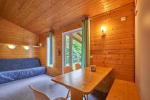 sala de estar con mesa y sofá en Chalet 5 personnes 302, en Mens