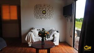 a living room with a couch and a table with a vase of flowers at Refugio Selvatico in Guatapé