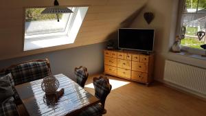 un soggiorno con un tavolo e una televisione di Ferienwohnung Kerstin in Strackholt Ostfriesland- Urlaub a Großefehn 