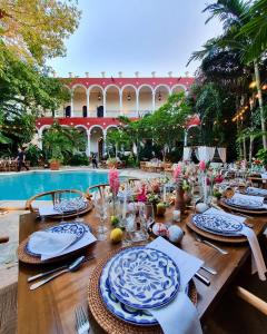 - une table pour un repas en face de la piscine dans l'établissement VILLA MERIDA BOUTIQUE HOTEL - Adults Only, à Mérida