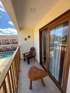 a balcony with a chair and a table and a pool at Pousada Deu Praia Maragogi in Maragogi +34 photos
