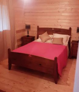 a bedroom with a large bed with a pink blanket at Casa do Baloiço do Pitagudo in Maceira