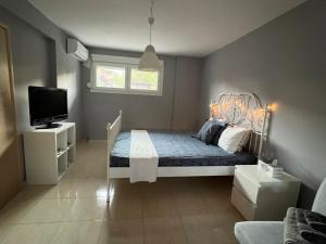 sypialnia z łóżkiem i telewizorem w obiekcie Studio Odysseus w mieście Nikiti