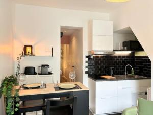 a kitchen with white cabinets and a table with chairs at Vieux-Lille - Deux pièces de charme in Lille +9 photos