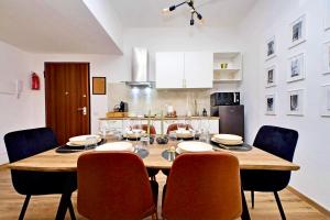 a dining room table and chairs in a kitchen at Domus Traiano - Port Apartment in Civitavecchia +28 photos