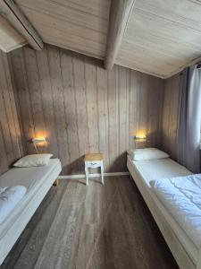 a room with two beds and a chair in it at Geilo Hytter & Camping in Geilo
