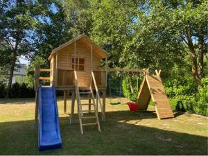 a playground with a play house and a slide at Apartamenty Na Wschodniej in Chłopy