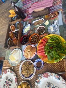 una mesa con platos de comida y tazones de comida en Derin Mavi Suit Butik Otel, en Sogut