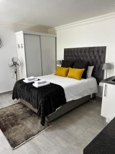 杰米斯顿Marielitsa Guest Suite No 9的卧室里有一张大床，上面有黄色枕头