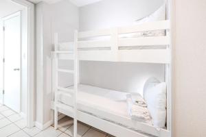 biały pokój z białym łóżkiem piętrowym w obiekcie Phoenix All Suites West Hotel w mieście Gulf Shores