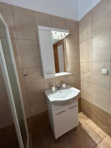 un bagno con un lavandino bianco e uno specchio di My lithos a Ios Chora