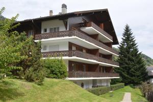 a building on top of a hill with trees at Apartment Champéry Grand Pré A in Champéry