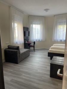 1 dormitorio con cama, sofá, cama y escritorio en Hotel König Humbert, en Erlangen