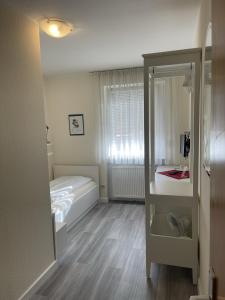 Habitación pequeña con cama y ventana en Hotel König Humbert, en Erlangen