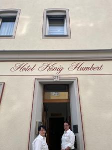 dos personas de pie en la puerta de un edificio en Hotel König Humbert, en Erlangen