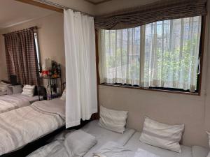Private Inn Bambee في كوبه: غرفة نوم بسريرين ونافذة كبيرة