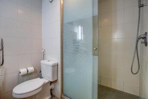 uma casa de banho com um WC e uma cabina de duche em vidro. em ibis Vitoria Praia de Camburi em Vitória