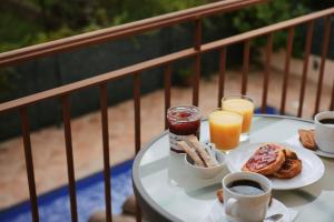 Villa Garbí by Alvent Holidays في كالونج: طاولة مع طعام الإفطار والمشروبات على شرفة