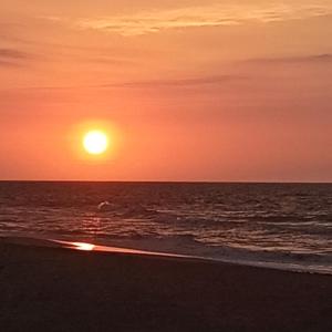 a sunset on the beach with the ocean at Hotel Juanmar in Juan de Acosta