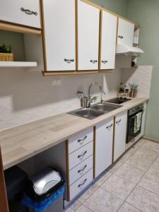 a kitchen with white cabinets and a sink at Villa Asteri Luxury Apartment Ouranoupoli in Ouranoupoli +14 photos