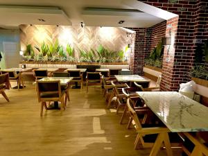 a restaurant with tables and chairs and plants on the wall at Double Bond Hotel Spa in Ankara