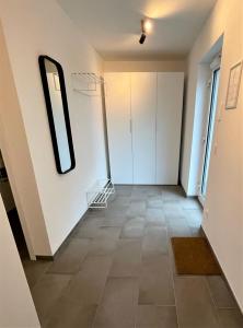 a hallway with white walls and a mirror at helloYOU Apartments in Ingelheim am Rhein