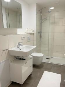 a bathroom with a sink and a toilet and a shower at helloYOU Apartments in Ingelheim am Rhein