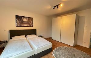 a bedroom with a large bed and a cabinet at helloYOU Apartments in Ingelheim am Rhein