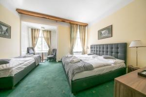 Pokój hotelowy z 2 łóżkami i biurkiem w obiekcie Hotel Bergwirt Schönbrunn w Wiedniu