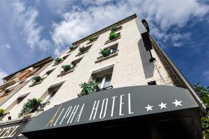 un edificio con un cartel frente a un hotel en Hotel Alpha Paris Eiffel by Patrick Hayat, en Boulogne-Billancourt