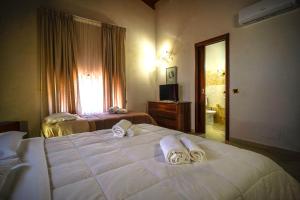 a hotel room with two beds and a bathroom at Tenuta Un Posto Al Sole Luxury B&B in Rossano Stazione