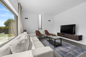 Una sala de estar con un sofá y un televisor. en Villa Kalu 1, en Krnica