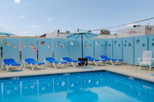 a swimming pool with blue chairs and a building at Ocean 7 in Ocean City +5 photos
