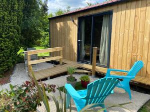 2 chaises bleues et un banc devant une cabine dans l'établissement Les gîtes de Belle Roche, à Mâcon