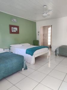 two beds in a room with green walls at LM Suítes in Búzios +74 photos