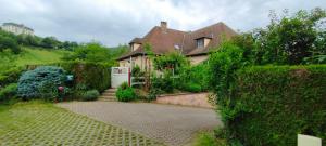 ein Haus mit einem Garten und einer Auffahrt in der Unterkunft LA FERME DES PERLES NOIRES in Ribeauvillé